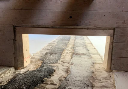 Van binnenuit zijn donker metselwerk en houten onderdelen rond het kanaal te zien.
